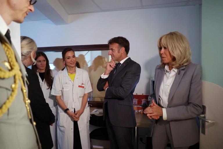 Le président Emmanuel Macron (c) et son épouse Brigitte Macron (d) rencontrent la pédiatre Tania Ikowsky lors d'une visite à l'unité UAPED (Unité d'Accueil Pédiatrique Enfant en Danger), une structure hospitalière spécialisée dans la prise en charge des enfants victimes de violence, de maltraitance ou de négligence, à l'hôpital Robert-Debré à Paris, le 10 juin 2026