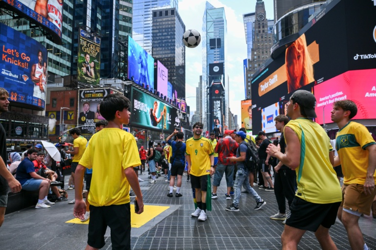 Des supporters brésiliens jouent au foot à Times Square, à New York, le 12 juin 2026
