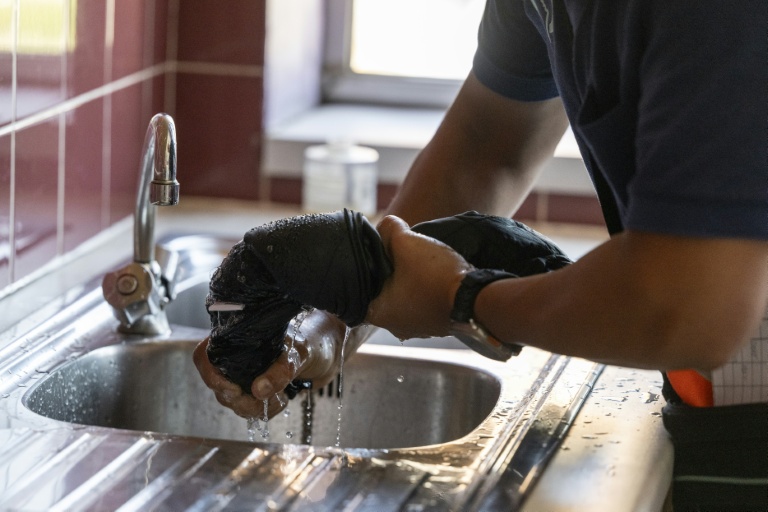 Avant utilisation, le gilet rafraîchissant doit être immergé dans l'eau fraîche et essoré, comme ici le 12 août 2025 à Châtillon, au sud de Paris