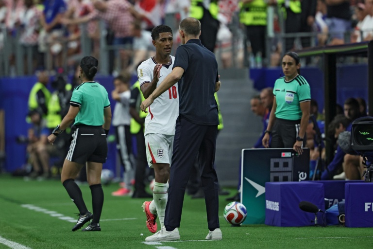 Le milieu de terrain anglais Jude Bellingham (au centre, à gauche), serre la main du sélectionneur allemand de l'équipe d'Angleterre, Thomas Tuchel, alors qu'il quitte le terrain pour être remplacé, lors du match du Mondial-2026 contre la Croatie, à Arlington, le 17 juin 2026