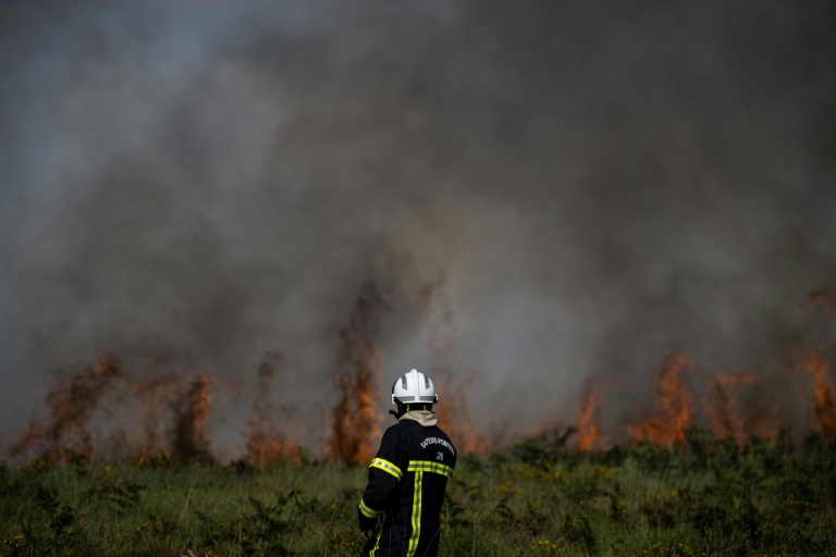 Un sapeur pompier lutte contre un incendie touchant les Monts d'Arrée, près de Brasparts (Finistère), le 19 juillet 2022