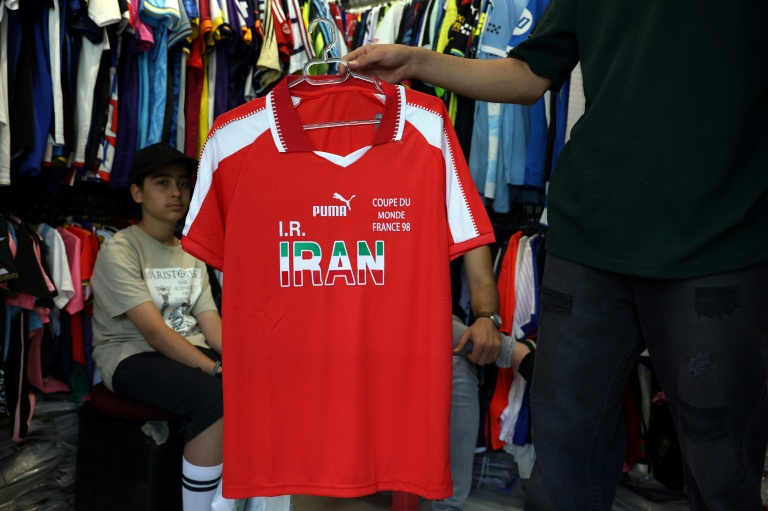 Un commerçant tient un ancien maillot de l'équipe nationale iranienne dans son magasin à Téhéran, le 8 mai 2026.