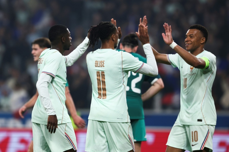 L'attaquant international français Michael Olise (c.) célèbre son premier but marqué contre l'Irlande du Nord en amical avec ses coéquipiers Kylian Mbappé (d.) et Ousmane Dembélé (g.), à Villeneuve-d'Ascq, le 8 juin 2026