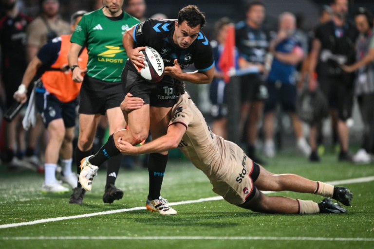 Arthur Vincent (G) porte le ballon pour Montpellier face à Lyon et Martin Meliande, lors d'une rencontre de Top 14, le 6 juin 2026 au stade de Gerland