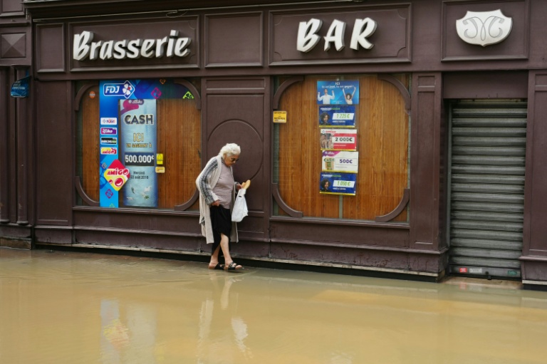 Une passante dans une rue inondée de Coulommiers (Seine-et-Marne), à l'est de Paris, le 10 octobre 2024