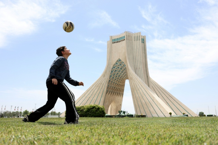 Un garçon iranien joue au football près de la tour Azadi à Téhéran le 7 mai 2026.