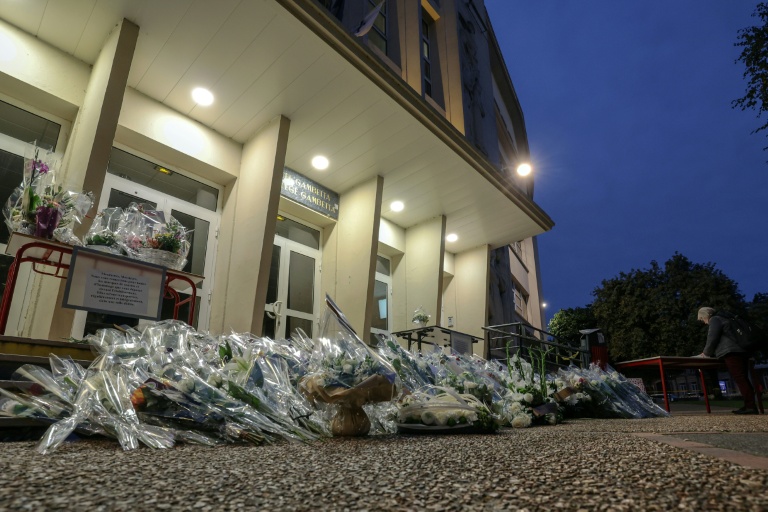 Des fleurs déposées devant le lycée Gambetta d'Arras en hommage au professeur de français Dominique Bernard, tué lors d'une attaque au couteau, le 13 octobre 2026 dans le Pas-de-Calais