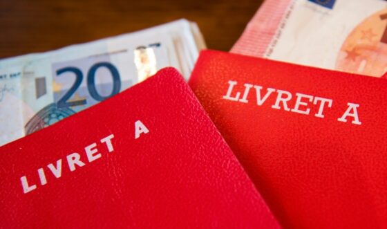 Deux livrets A avec des billets de 20 euros en arrière-plan.