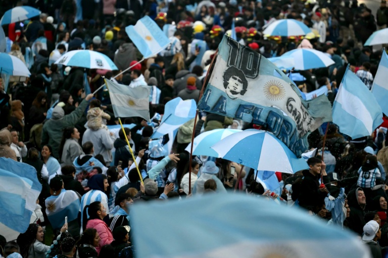 Un supporter agite un drapeau à l'effigie de Diego Maradona, légende du football argentin, près du centre d'entraînement de la Fédération argentine de football (AFA) à Ezeiza, dans la province de Buenos Aires, le 20 juillet 2026