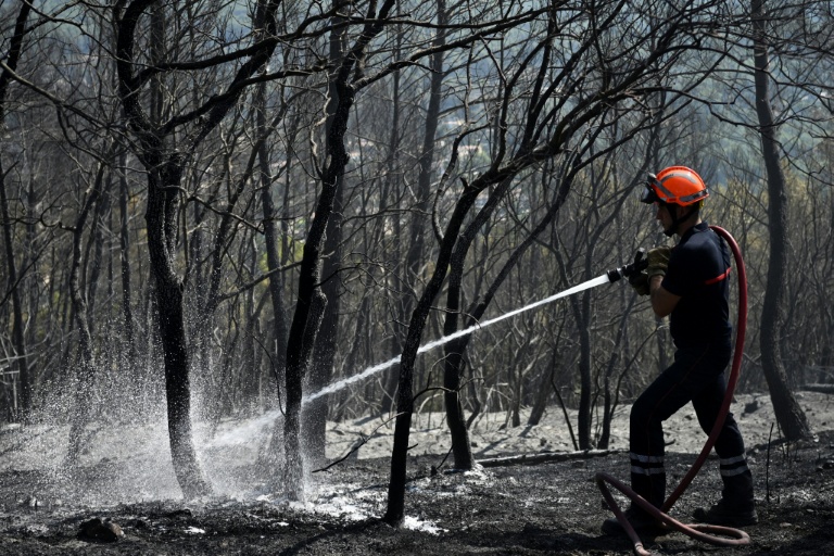 Un pompier arrose une zone brûlée à Cotignac, dans le Var, le 24 juillet 2026