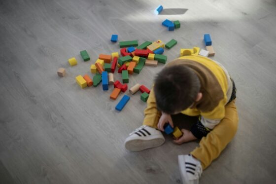 Un enfant joue avec des blocs de construction sur le sol.