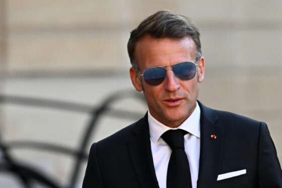 Emmanuel Macron portant des lunettes de soleil lors d'un événement.