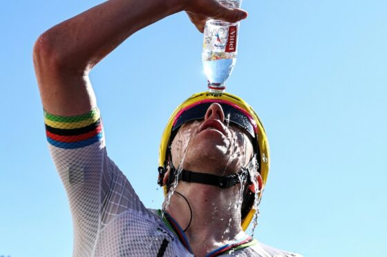 Un coureur du Tour de France s'asperge d'eau pour se rafraîchir sous la chaleur extrême.