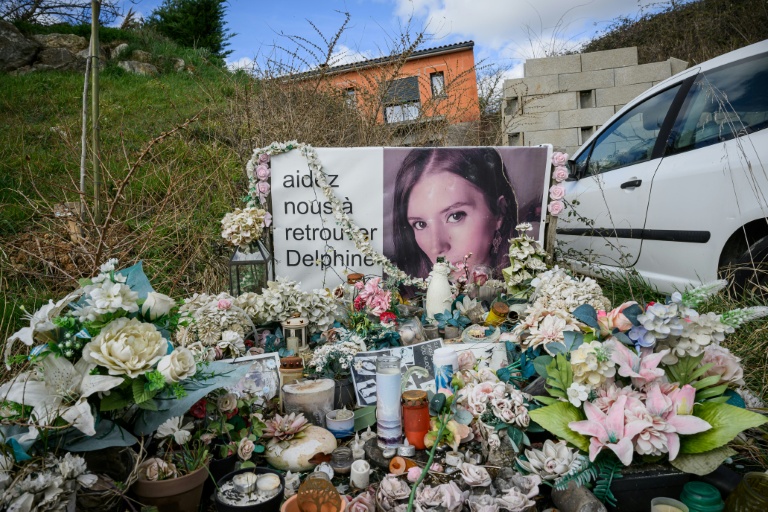 Des bougies et des fleurs déposées devant un portrait de Delphine Jubillar, près de sa maison à Cagnac-les-Mines, le 6 mars 2025 dans le Tarn