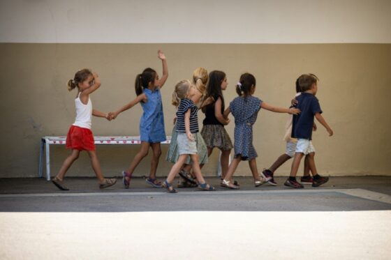 Des enfants marchent ensemble dans une cour d'école.