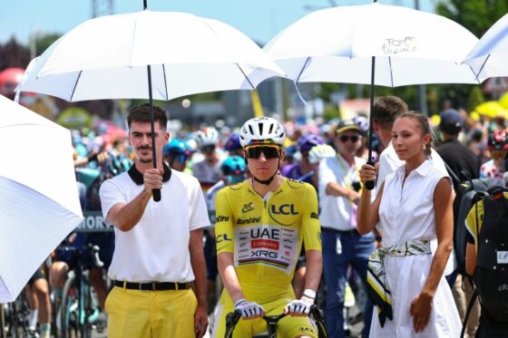 Tadej Pogacar lors de la 6e étape du Tour de France, avec des coureurs sous des parapluies.