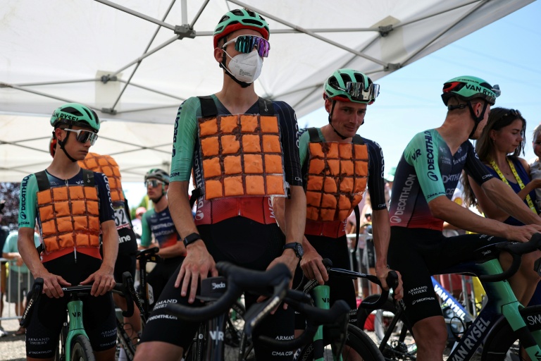 Les coureurs de Decathlon CMA CGM dont leur jeune leader Paul Seixas (avec un masque) porte des gilets refrigérants avant le départ de la 9e étape du Tour de France, à Ussel, le 12 juillet 2026