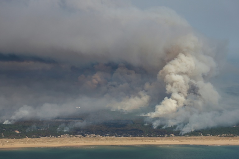 Plan aérien d'un incendie de forêt au nord du bassin d'Arcachon, dans le sud-ouest de la France, le 24 juillet 2026

This aerial photograph shows smoke emanating from the wildfire north of the Arcachon basin (seen Top) covering the forest, with a view of a beach and the Atlantic Ocean (bottom) near Lege-Cap-Ferret, southwestern France, on July 24, 2026.  France has been battered by three heatwaves since May as part of increasingly common extreme weather episodes linked to climate change, causing excess deaths, drying up rivers and fuelling wildfires. Scientists have long warned that climate change caused by human use of fossil fuels will make periods of drought more intense and longer-lasting, creating the ideal conditions for wildfires.