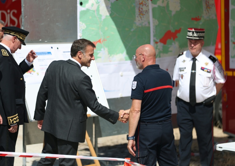 Emmanuel Macron serre la main à un pompier lors de sa visite au poste de commandement à Fontainebleau.