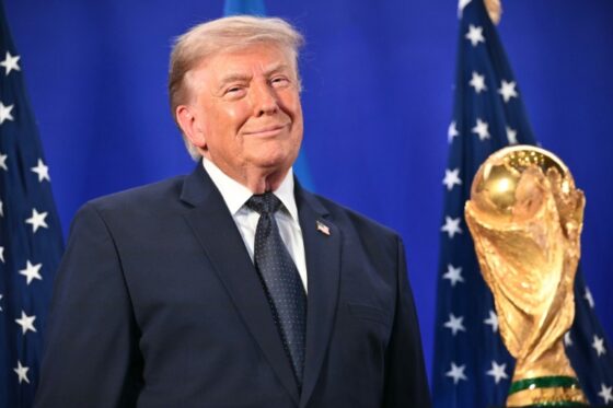 Donald Trump souriant devant le trophée de la Coupe du monde 2026.
