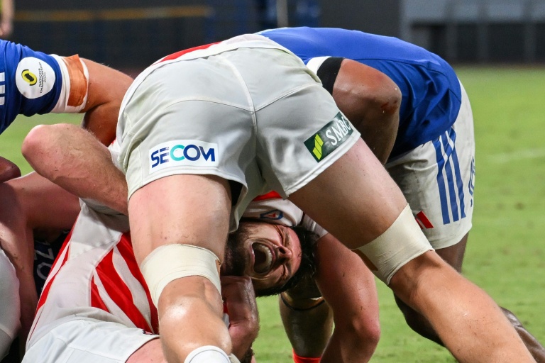 Le Japonais Jack Cornelsen plaqué par des Français pendant le match de Championnat des nations samedi à Tokyo.