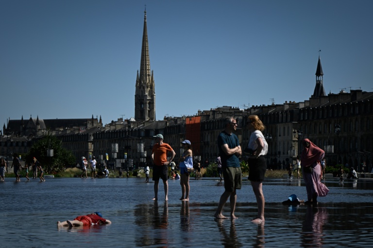 Des personnes se rafraîchissent dans le Miroir d'eau, sur les rives de la Garonne, lors d'une vague de chaleur estivale à Bordeaux, dans le sud-ouest de la France, le 6 juillet 2026.