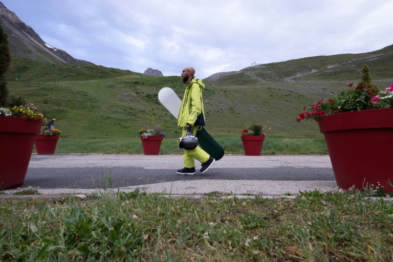 Un snowboardeur se dirige vers le funiculaire de la Grande Motte , le 11 juillet 2026 à Tignes, en Savoie
