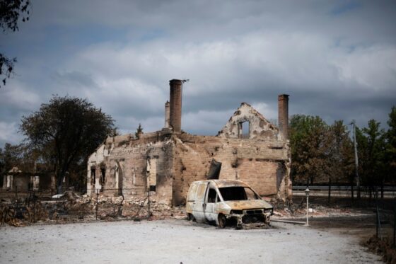 Un véhicule brûlé devant une maison détruite par les incendies en Gironde.