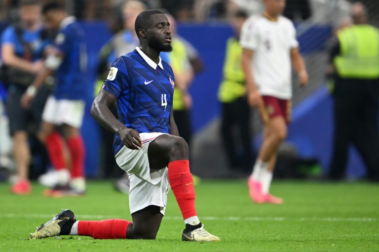 Un joueur de l'équipe de France à genoux sur le terrain lors d'un match.