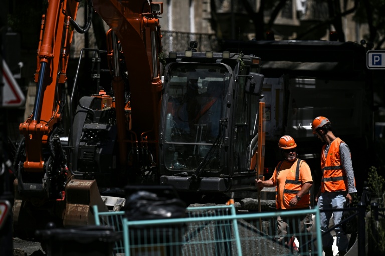 Des ouvriers font une pause sur un chantier de nivellement de chaussée à Bordeaux, le 6 juillet 2026 en Gironde, lors d'une nouvelle vague de chaleur en France