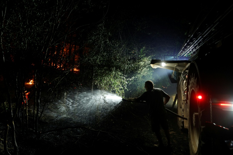 Un agriculteur arrose la forêt de Fontainebleau, après qu'un incendie de forêt s'est déclaré en fin d'après-midi à Noisy-sur-École, le 12 juillet 2026