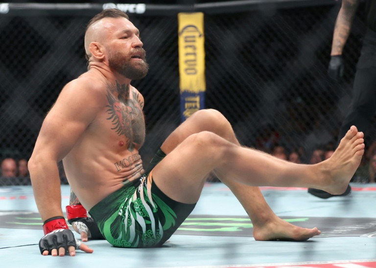 Conor McGregor assis sur le ring après sa blessure lors du combat contre Max Holloway