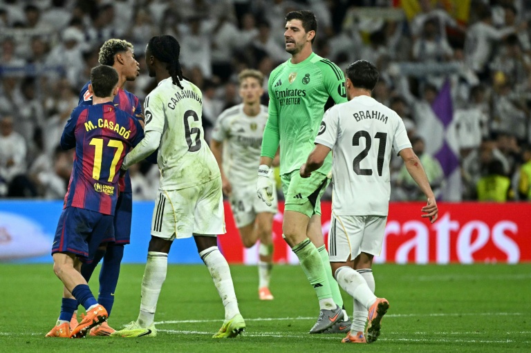 Echange tendu entre Lamine Yamal (2e à gauche, masqué partiellement par Casado) et Thibaut Courtois (2e à droite) lors d'un clasico en championnat entre le Real Madrid et FC Barcelone le 26 octobre 20258 à Santiago-Bernabeu