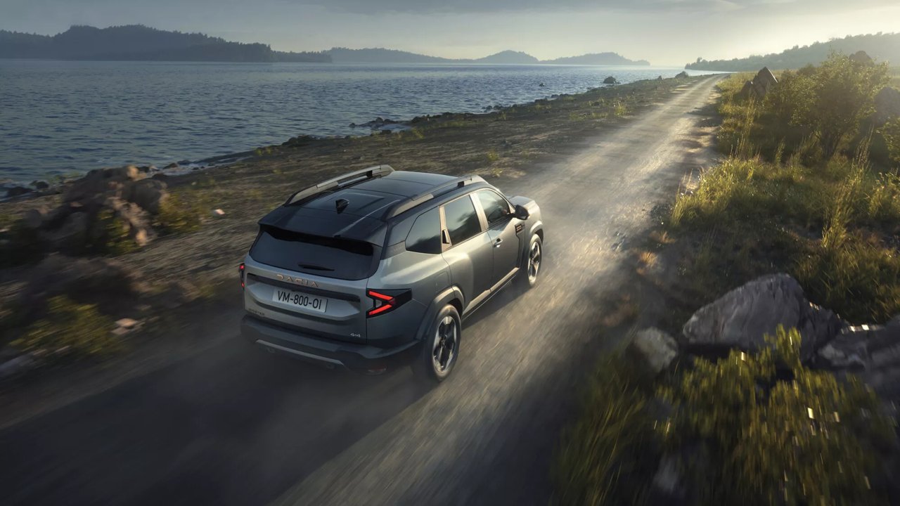 Dacia Bigster hybride vu de trois-quarts arrière sur une route de montagne