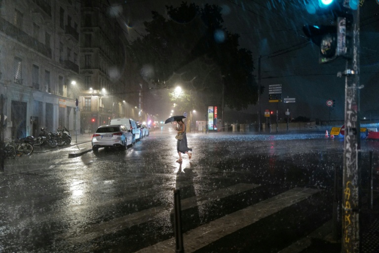 Une passante dans une rue de Lyon pendant un orage, le 16 juillet 2026