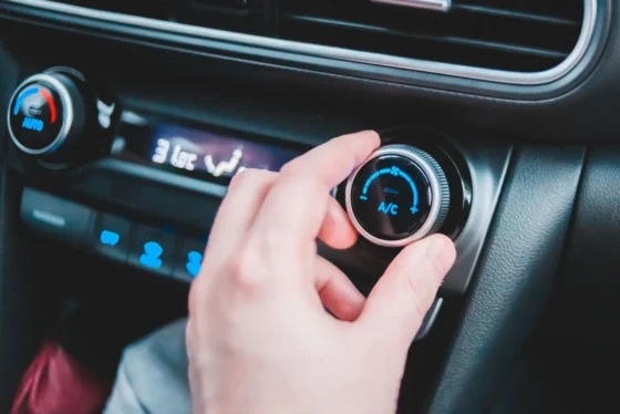 Conducteur réglant la climatisation de sa voiture sur la commande A/C