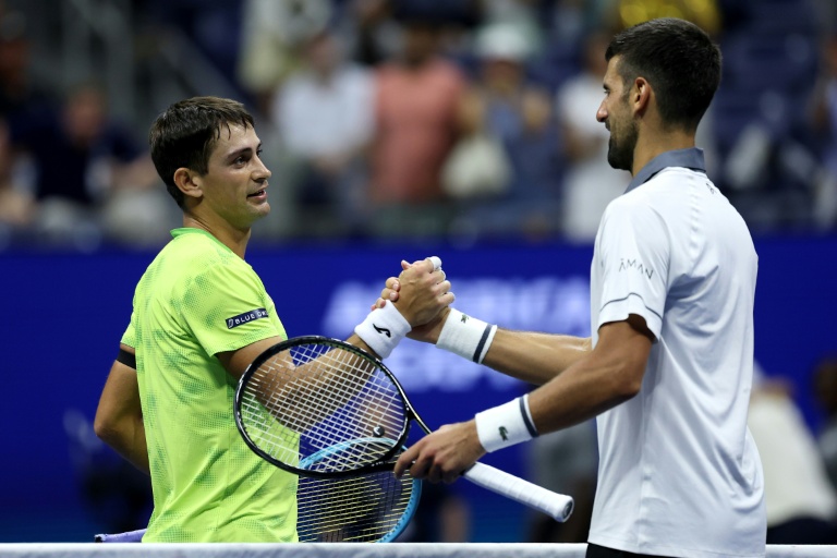 L'Argentin Mariano Navone sert la main du Serbe Novak Djokovic après leur match du premier tour de l'US Open 2026, le 30 août 2026, à New York