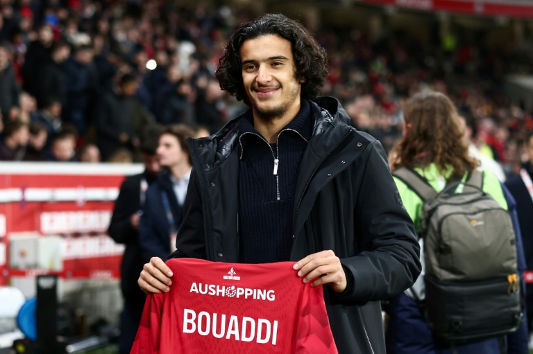 Ayyoub Bouaddi, souriant, tenant un maillot, symbolisant son transfert à Manchester City.