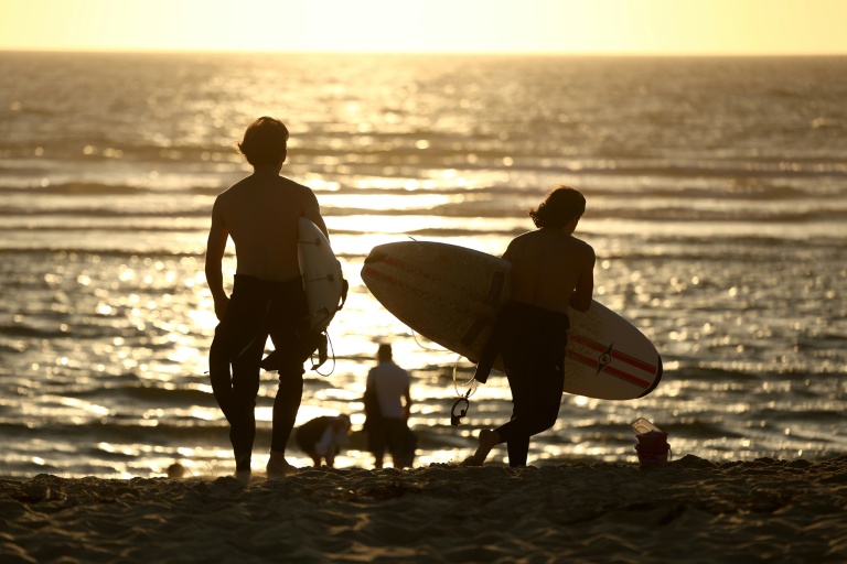 Des surfeurs sur la plage du Porge (Gironde), où quelque 220 personnes se sont retrouvées le 7 août 2026  pour une soirée de solidarité après le mégafeu qui ravagé la commune