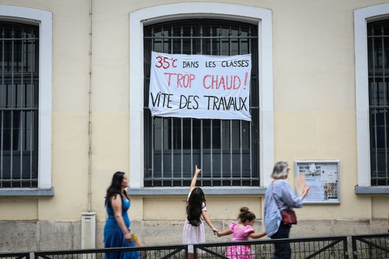 Une banderole sur laquelle est inscrit « 35 degrés dans les salles de classe, trop chaud. Des travaux doivent être réalisés rapidement » devant une école à Paris, le 18 juin 2026