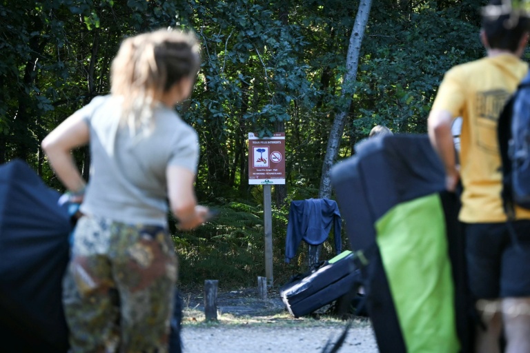 Des visiteurs devant un panneau 