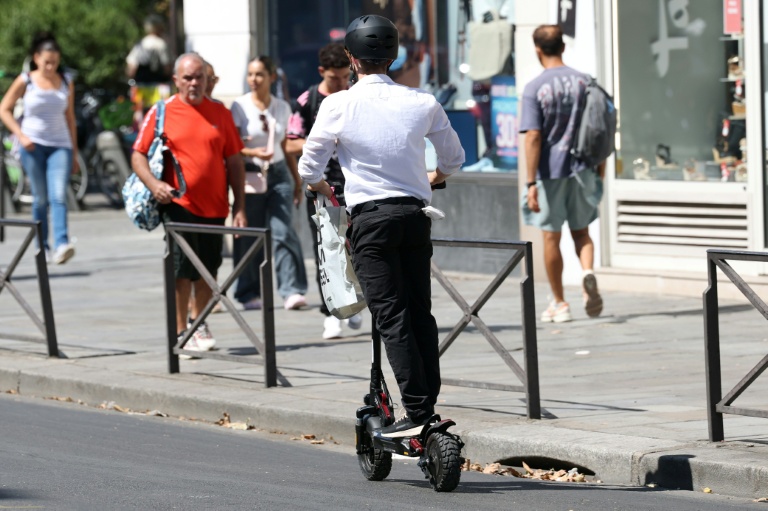 Un homme roule en trottinette électrique dans une rue de Paris, le 11 août 2026