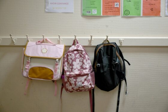 Des sacs à dos accrochés dans une école pour la rentrée scolaire 2026.