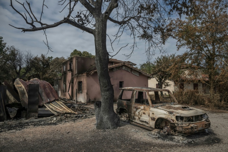 Une voiture calcinée devant une maison détruite par l'incendie, au Porge, dans le sud-ouest de la France, le 31 juillet 2026