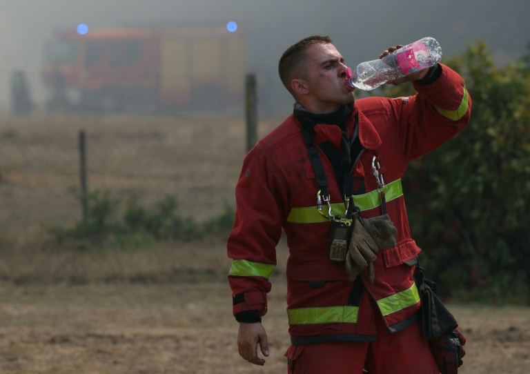 Un pompier s'hydrate à l'aide d'une gourde lors des opérations de lutte contre un incendie de forêt près de Lanton, dans le sud-ouest de la France, le 29 juillet 2026