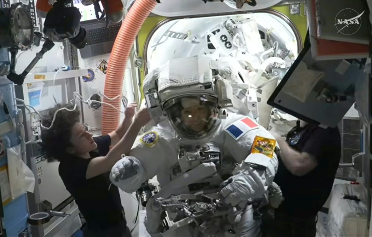 Image, extraite d'un flux vidéo en direct de la NASA et datée du 18 août 2026, montre l'astronaute française Sophie Adenot (au centre) rentrant à l'intérieur de la Station spatiale internationale (ISS) après sa première sortie dans l'espace