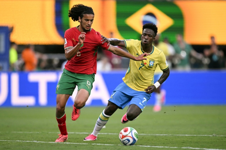 Le milieu de terrain Ayyoub Bouaddi, sous le maillot du Maroc, devance l'attaquant brésilien Vinicius Junior, lors de leur premier match de poule (1-1) à la Coupe du monde, le 13 juin 2026 à East Rutherford