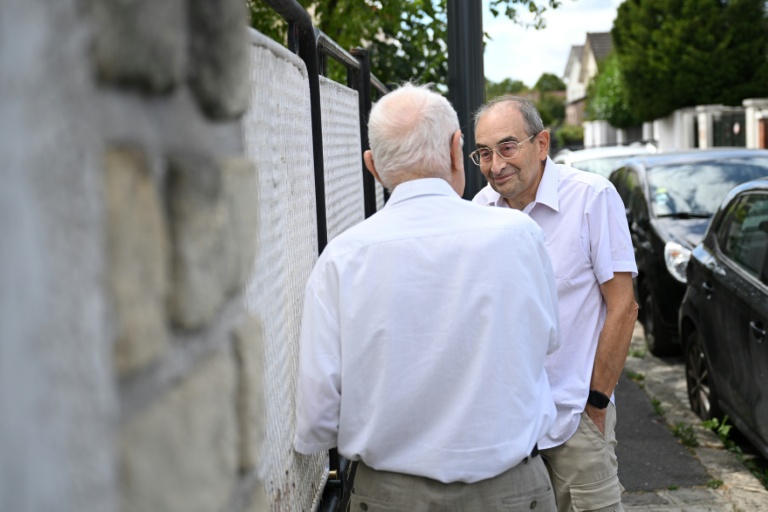 Stanislas Melka, bénévole de l'association Petits Frères des pauvres, en discussion avec un retraité de Colombes (Hauts-de-Seine), le 5 août 2026