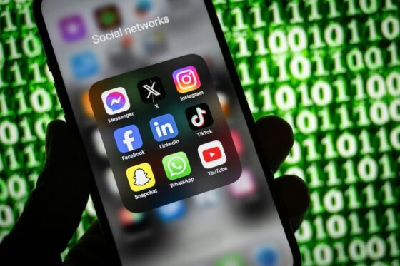 Un smartphone affichant des icônes de réseaux sociaux, sur fond numérique.