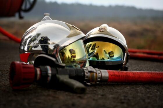 Casques de pompiers et équipements de lutte contre les incendies dans un paysage forestier.